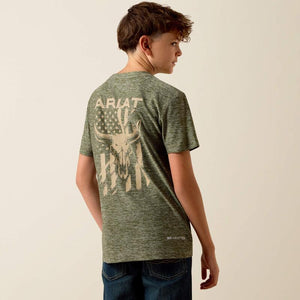 Person wearing a green t-shirt with a graphic design on the back against a beige background