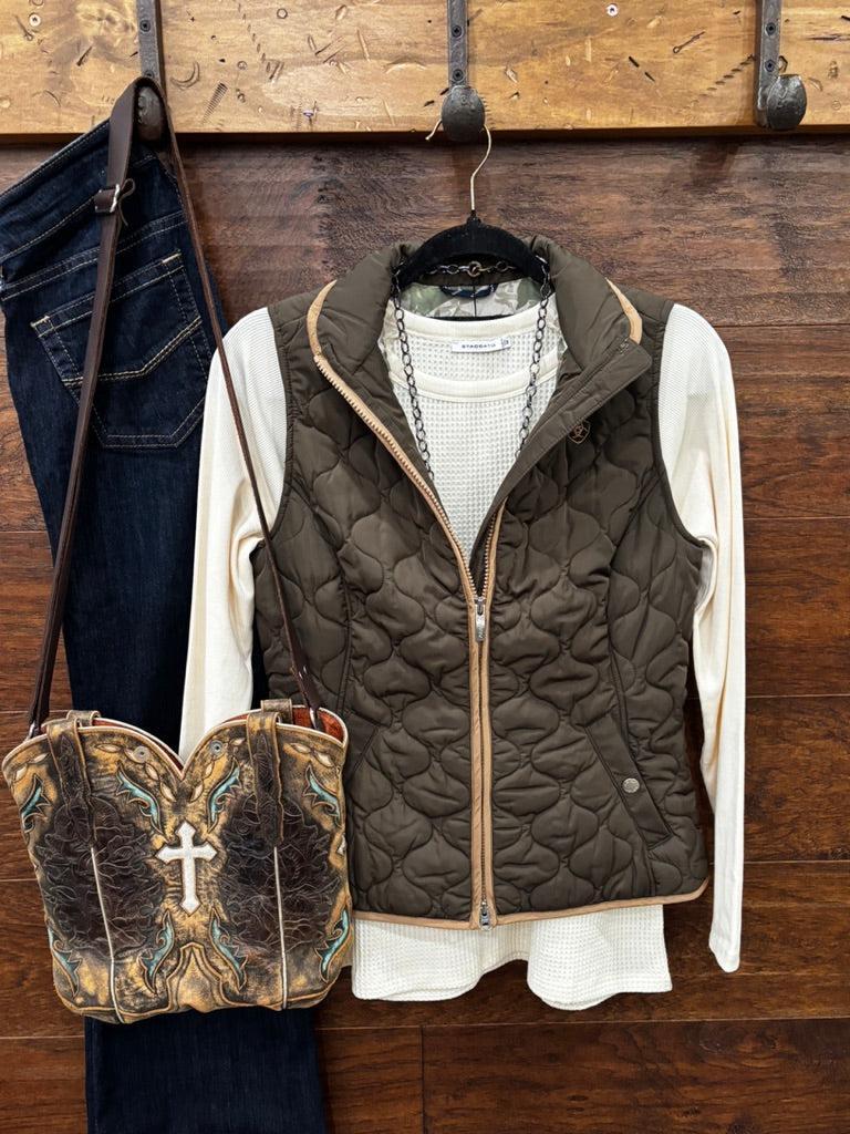 An earth tome quilted zip-up vest layered over a cream knit sweater
