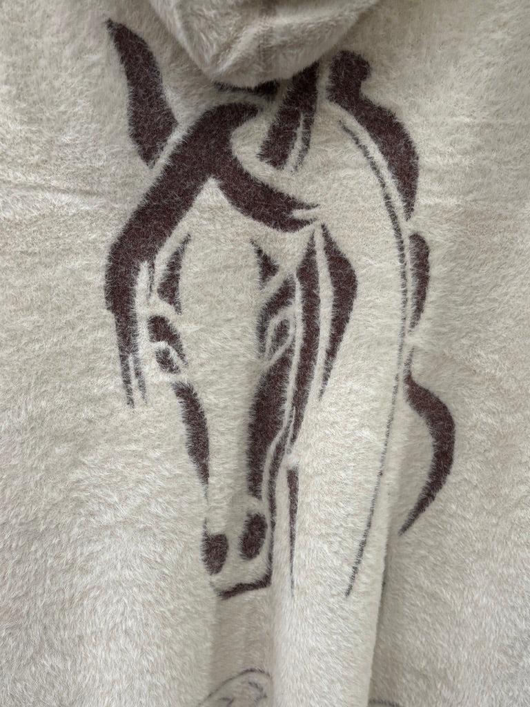 A cream-colored fuzzy knit hooded sweater with a brown horse graphic and geometric patterns. 