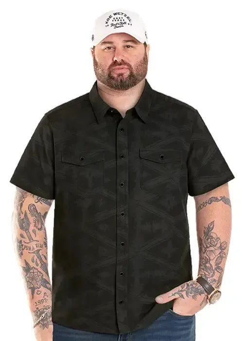 Man wearing a black patterned shirt and white cap on a white background