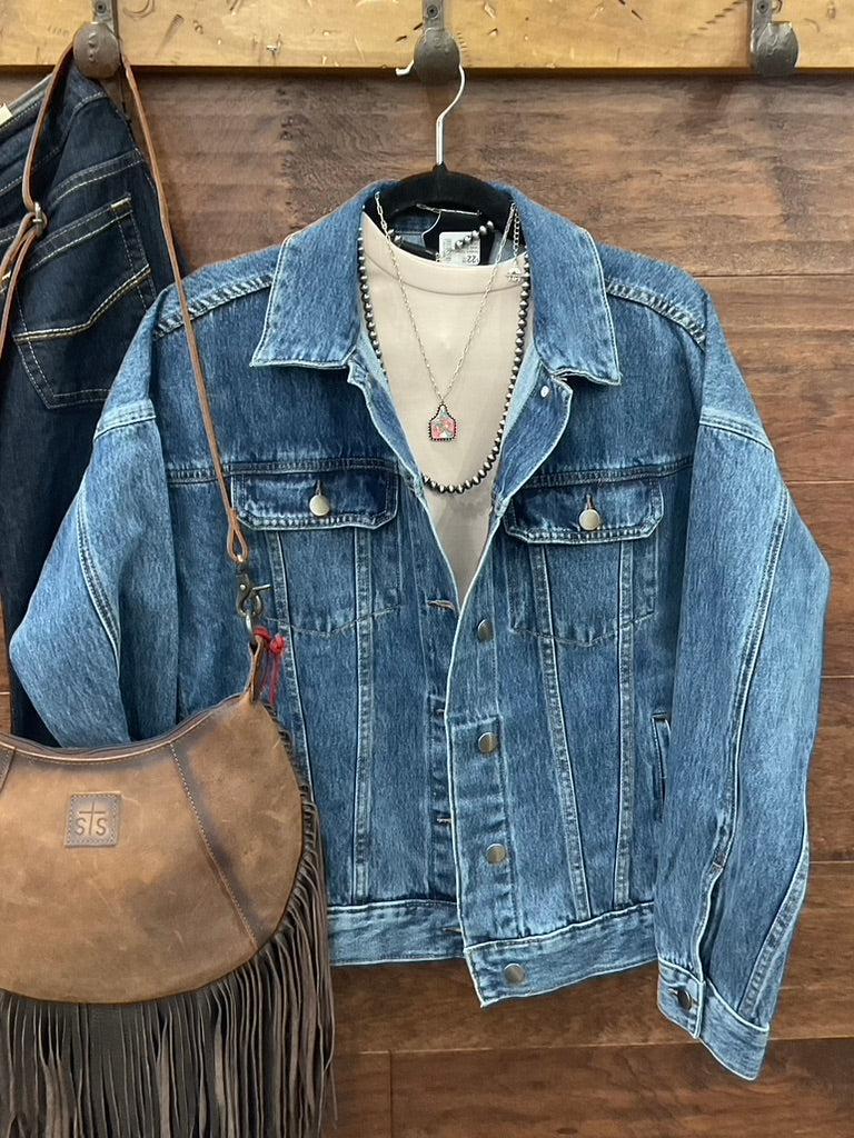 A blue denim jacket with a large embroidered steer skull design on the back. 
