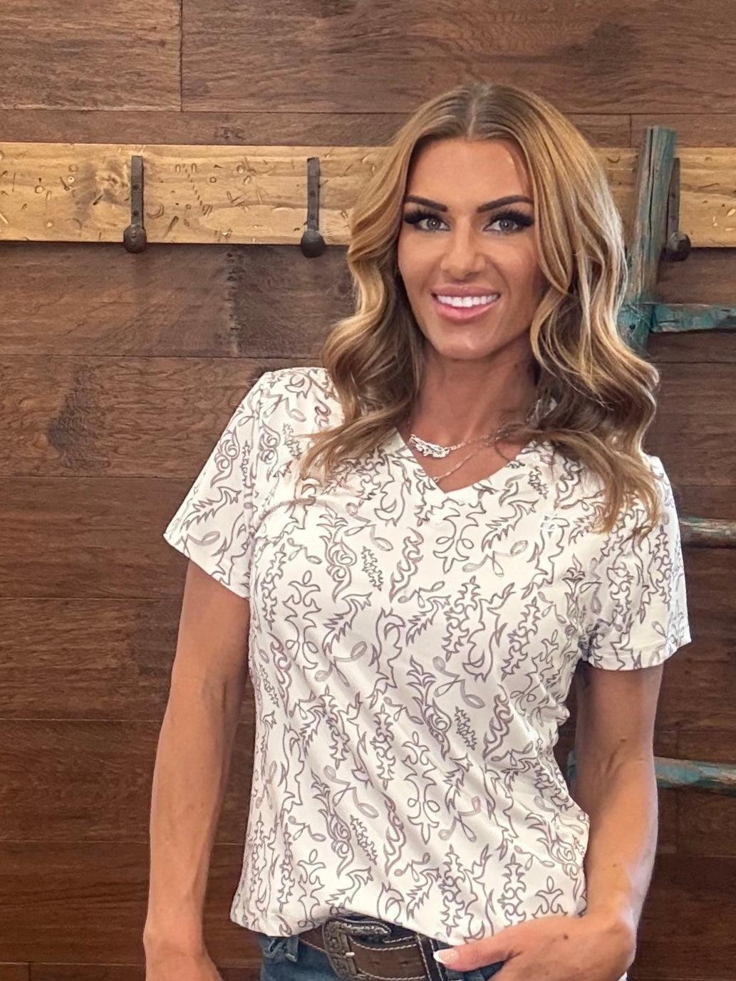 Woman wearing a floral blouse standing against a wooden background