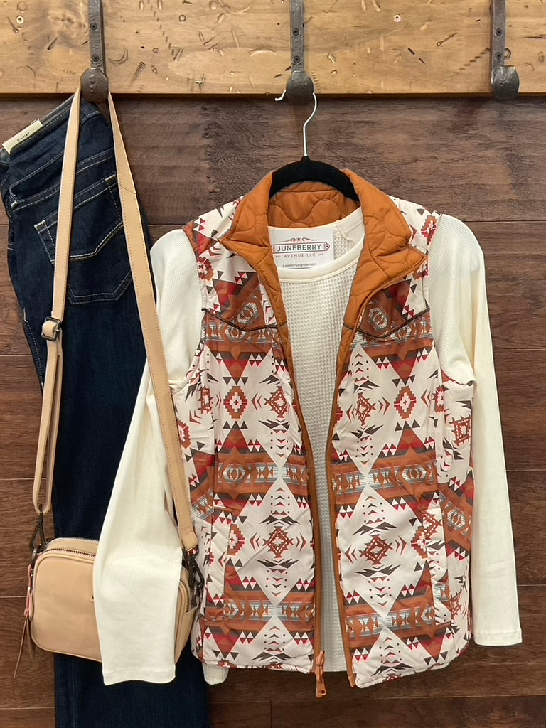  Reversible vest, featuring a striking Aztec print on one side and a solid camel finish on the reverse. 