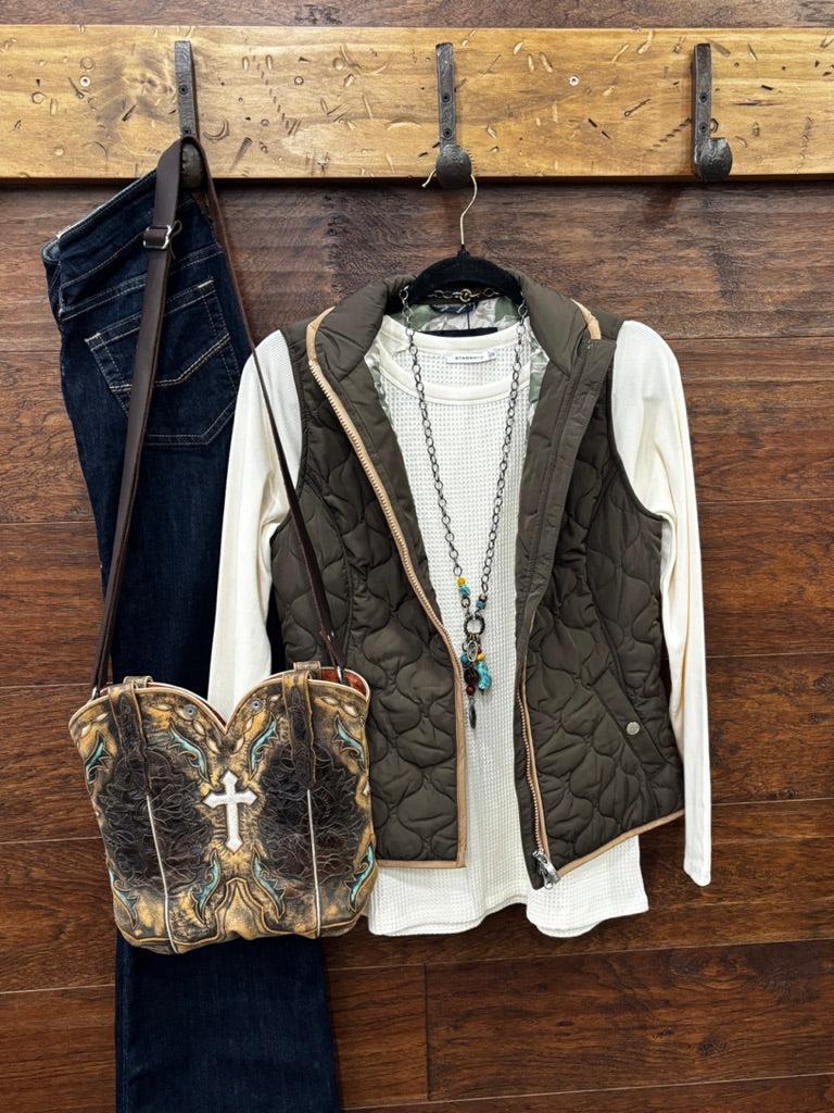 An earth tome quilted zip-up vest layered over a cream knit sweater