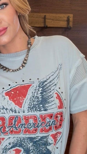Person wearing a t-shirt with an eagle design and 'American' text.