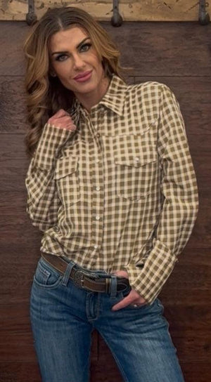 Woman wearing a checkered shirt and jeans against a wooden background