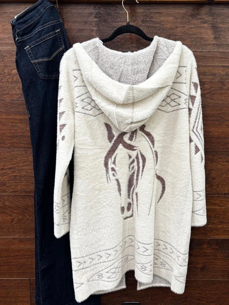 A cream-colored fuzzy knit hooded sweater with a brown horse graphic and geometric patterns. 