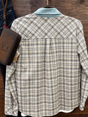 A long-sleeve plaid overshirt with a light blue collar, shown hanging on a wooden surface next to a brown leather crossbody bag and blue jeans.