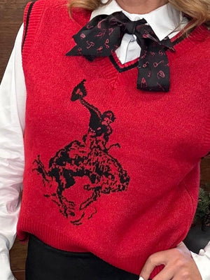 A red knit sweater vest worn over a white collared shirt, featuring a large black cowboy riding a bucking horse graphic on the front and a black bow tie with a small red pattern.