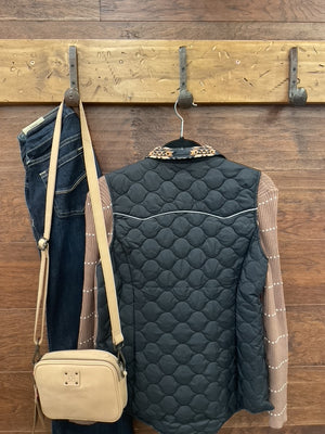 A black quilted zip-front vest with decorative tan and black geometric embroidery on the collar