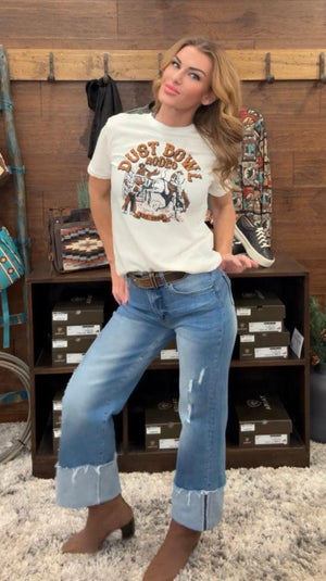 Person wearing blue jeans standing in front of a wooden shelf.