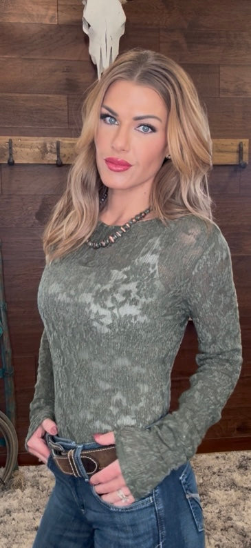 Woman wearing a green patterned long-sleeve top 