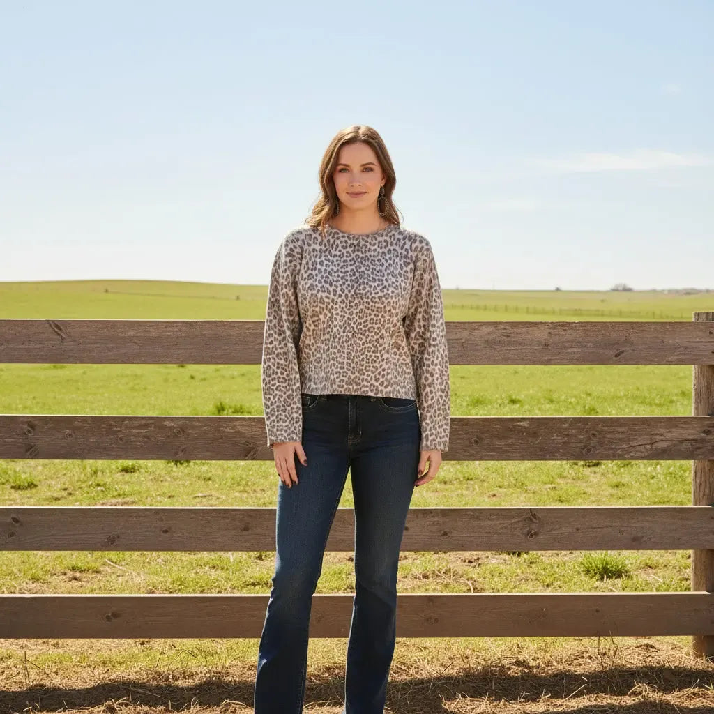 A woman wearing a beige and brown cheetah print knit sweater. 