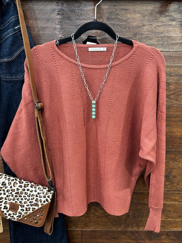 This sweater features a refined vertical texture, long dolman sleeves, and a classic boat neckline 