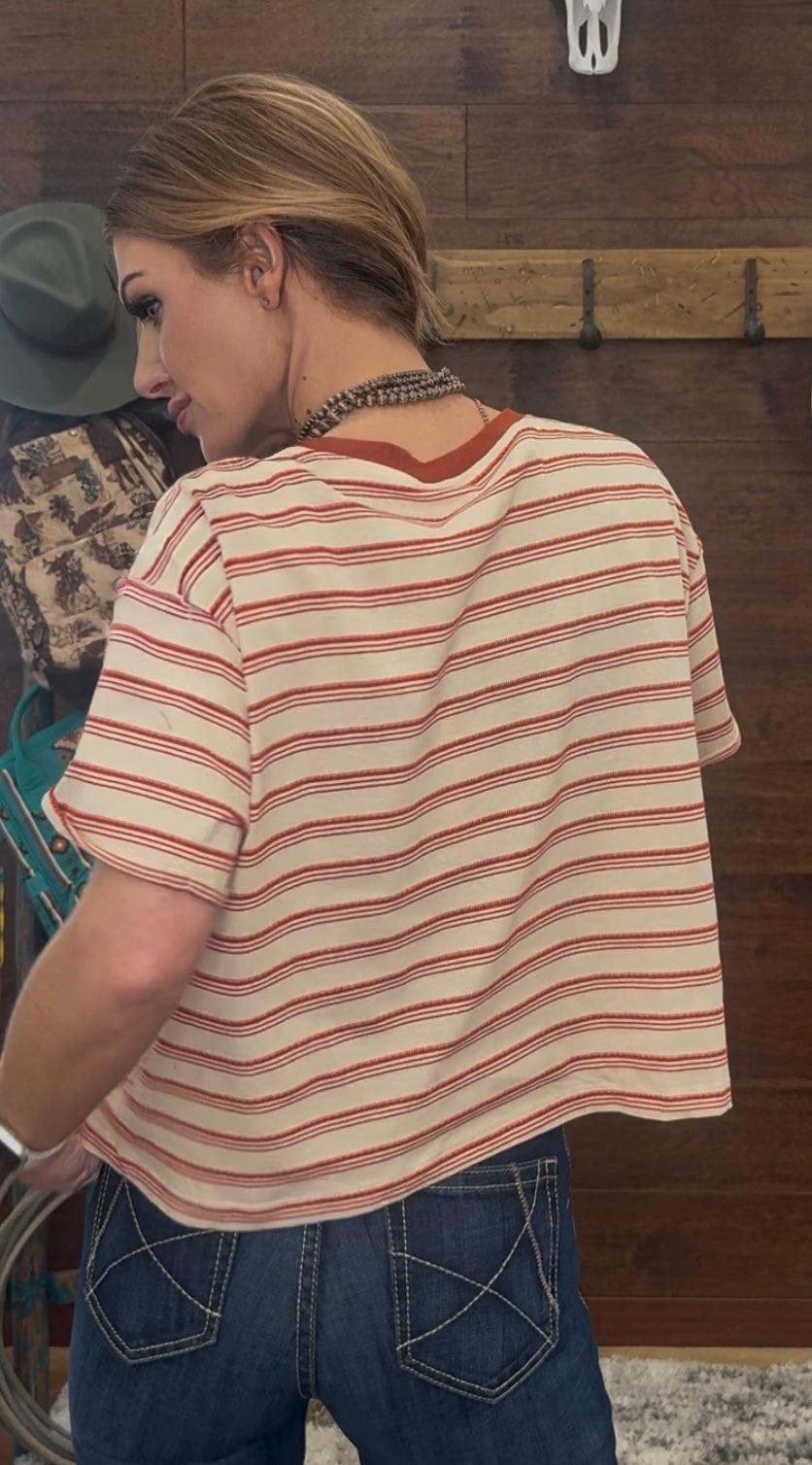 Woman wearing a striped shirt and jeans in a kitchen setting