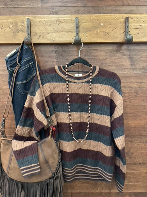 A striped cable-knit sweater in brown, beige, and charcoal. 