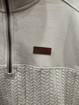 A cream-colored quarter-zip pullover sweater with a textured chevron pattern on the lower half