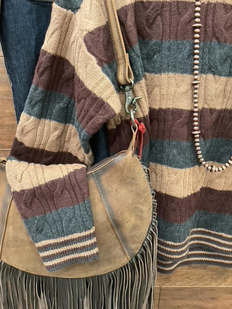 A striped cable-knit sweater in brown, beige, and charcoal. 