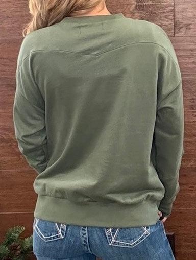 A person viewed from the back wearing an olive green long-sleeve crewneck sweatshirt and blue jeans, standing against a brown wooden wall.