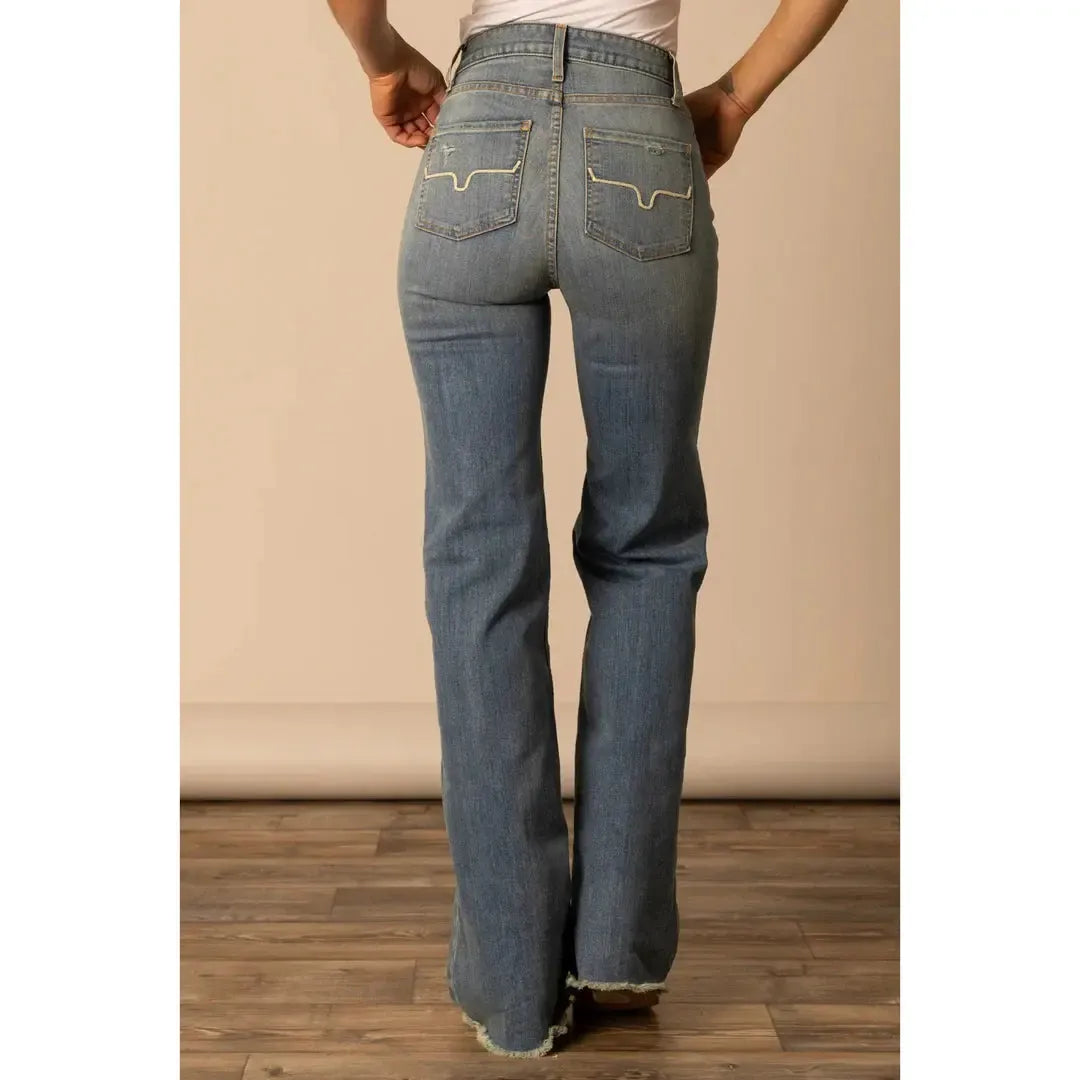 Person wearing blue jeans with a neutral background