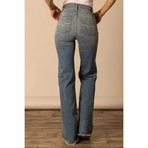 Person wearing blue jeans with a neutral background