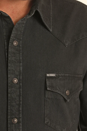 A man wearing a black western long-sleeve snap-down shirt 