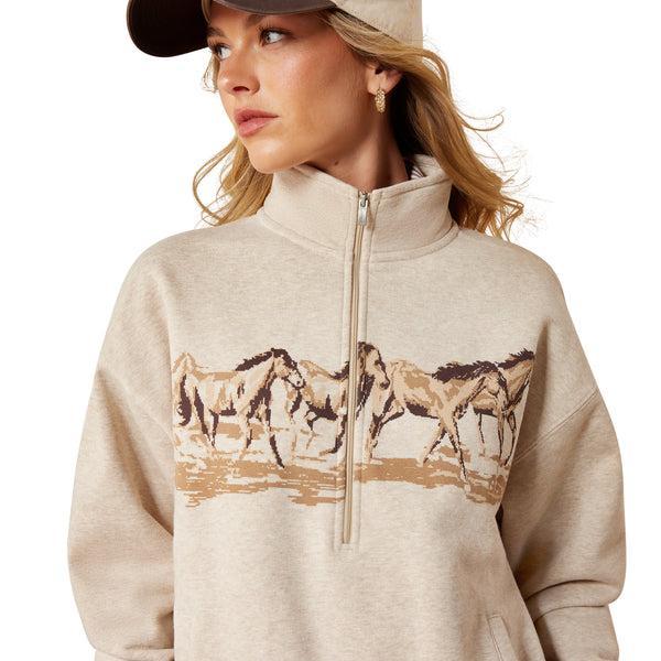 Woman wearing a beige sweatshirt with horse design on a white background