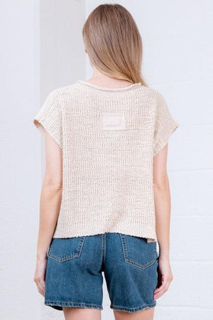 Woman wearing a beige textured top 