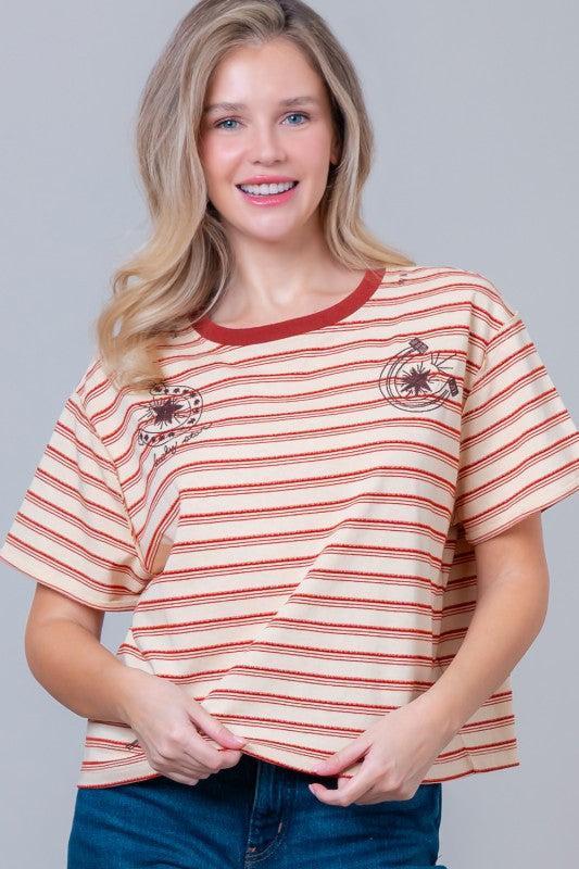 Woman wearing a striped t-shirt with small graphic designs 