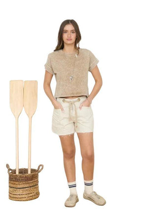 Woman wearing a brown short sleeve top.