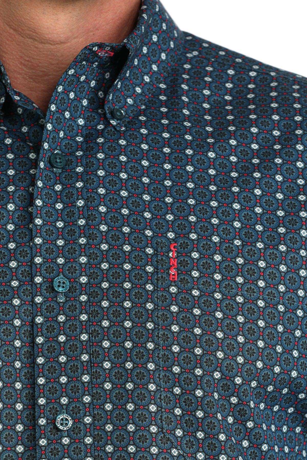 Close-up of a patterned shirt with a brand logo on a white background