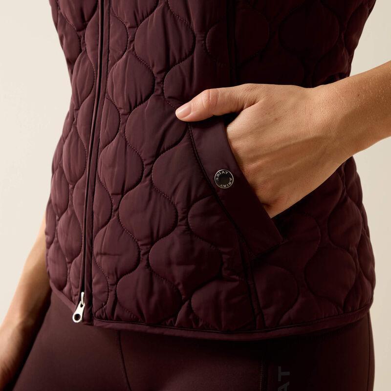 A woman modeling a dark plum quilted zip-front vest 