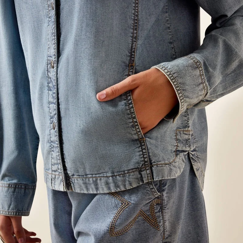 Woman wearing a denim shirt against a beige background