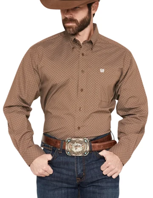 A man wearing a brown long-sleeve western shirt with a subtle micro-check pattern, paired with blue jeans, a brown leather belt, and a large western-style buckle, against a plain white background.