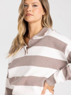 A woman wearing a cropped long-sleeve knit sweater with horizontal taupe and white stripes