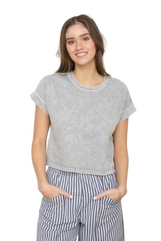 Woman wearing a grey short sleeve top.