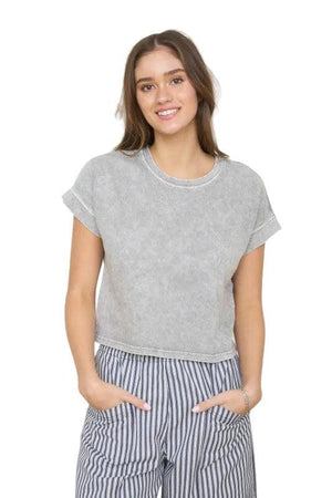 Woman wearing a grey short sleeve top.