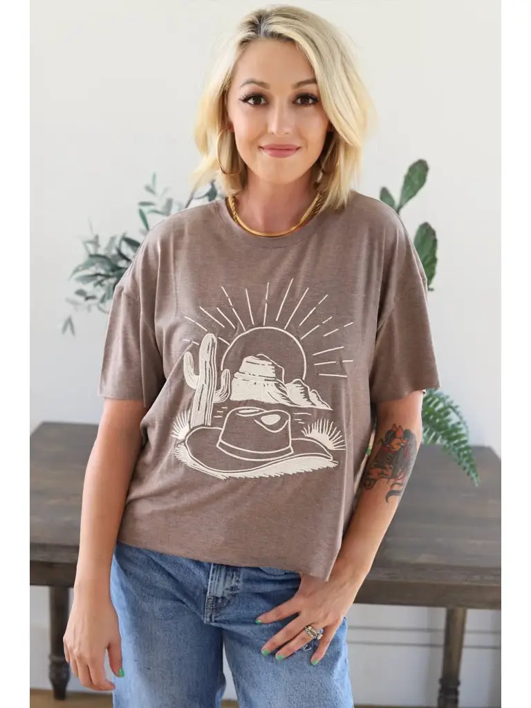 Brown t-shirt featuring a graphic design of a hat and cactus.