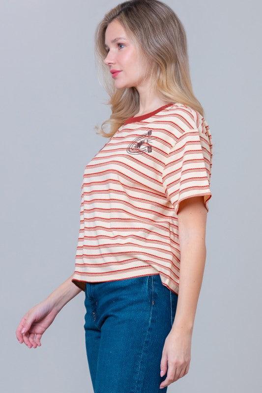 Woman wearing a striped t-shirt with small graphic designs 