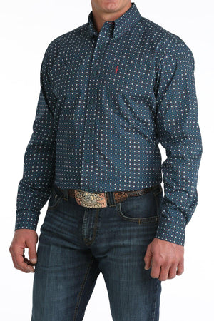 Man wearing a blue patterned shirt and jeans on a white background