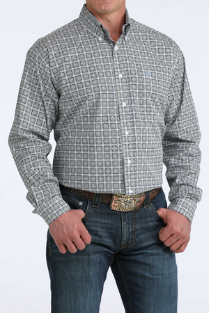Man wearing a patterned shirt and jeans on a white background