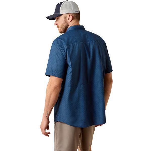 Man wearing a blue shirt and beige cap on a white background