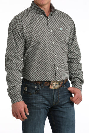 Man wearing a patterned shirt and jeans on a white background