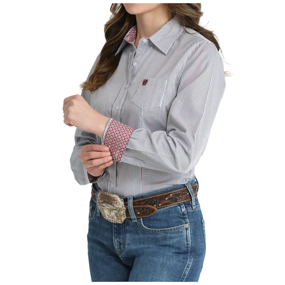 Woman wearing a striped shirt and jeans with a belt on a white background