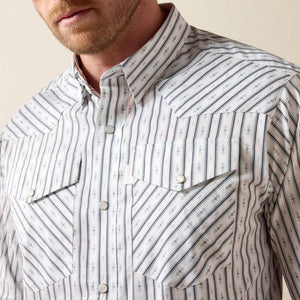 A man wearing a long-sleeve western-style button-down shirt with thin vertical blue and white stripes