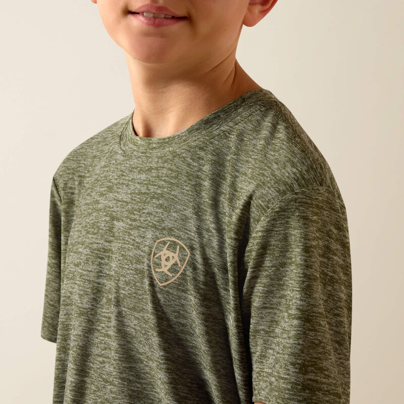 Child wearing a green long-sleeve shirt with a logo on a beige background