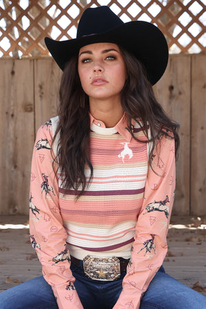 Woman wearing a striped sleeveless top with a belt buckle in an outdoor setting