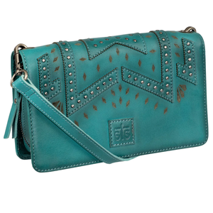 Teal leather handbag with decorative patterns and studded details on a white background
