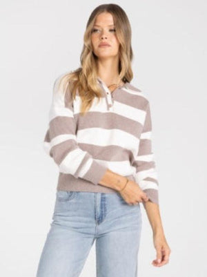 A woman wearing a cropped long-sleeve knit sweater with horizontal taupe and white stripes