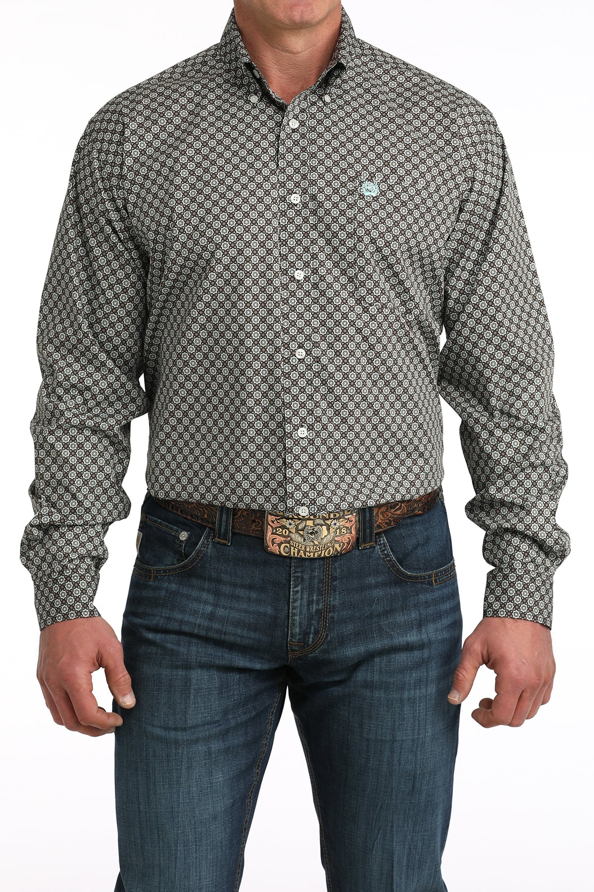Man wearing a patterned shirt and jeans on a white background